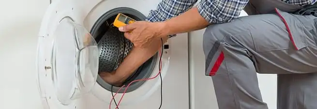 Dryer repair technician inspecting and repairing a clothes dryer in Eugene, OR