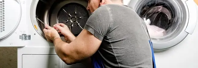Dryer repair technician fixing a clothes dryer drum in Eugene, OR