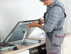 Appliance repair technician installing a built-in cooktop in Eugene, OR