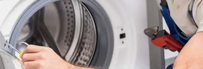 Appliance technician repairing a clothes dryer drum and internal parts in Eugene, OR