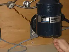 Garbage disposal repair technician tightening the mounting ring under a sink in Eugene, OR