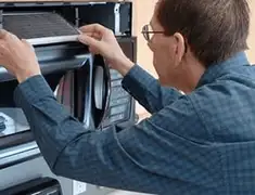 Appliance repair technician replacing a microwave vent filter in Eugene, OR