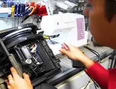 Vacuum repair technician servicing internal components on a workbench in Eugene, OR