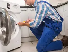 Washing machine repair technician servicing a front-load washer in Eugene, OR